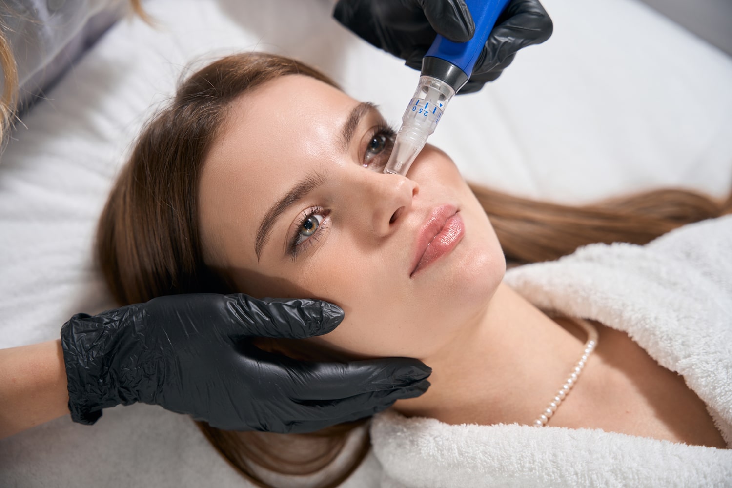 Beautician doing ultrasonic cleaning of waman face skin with skinpen